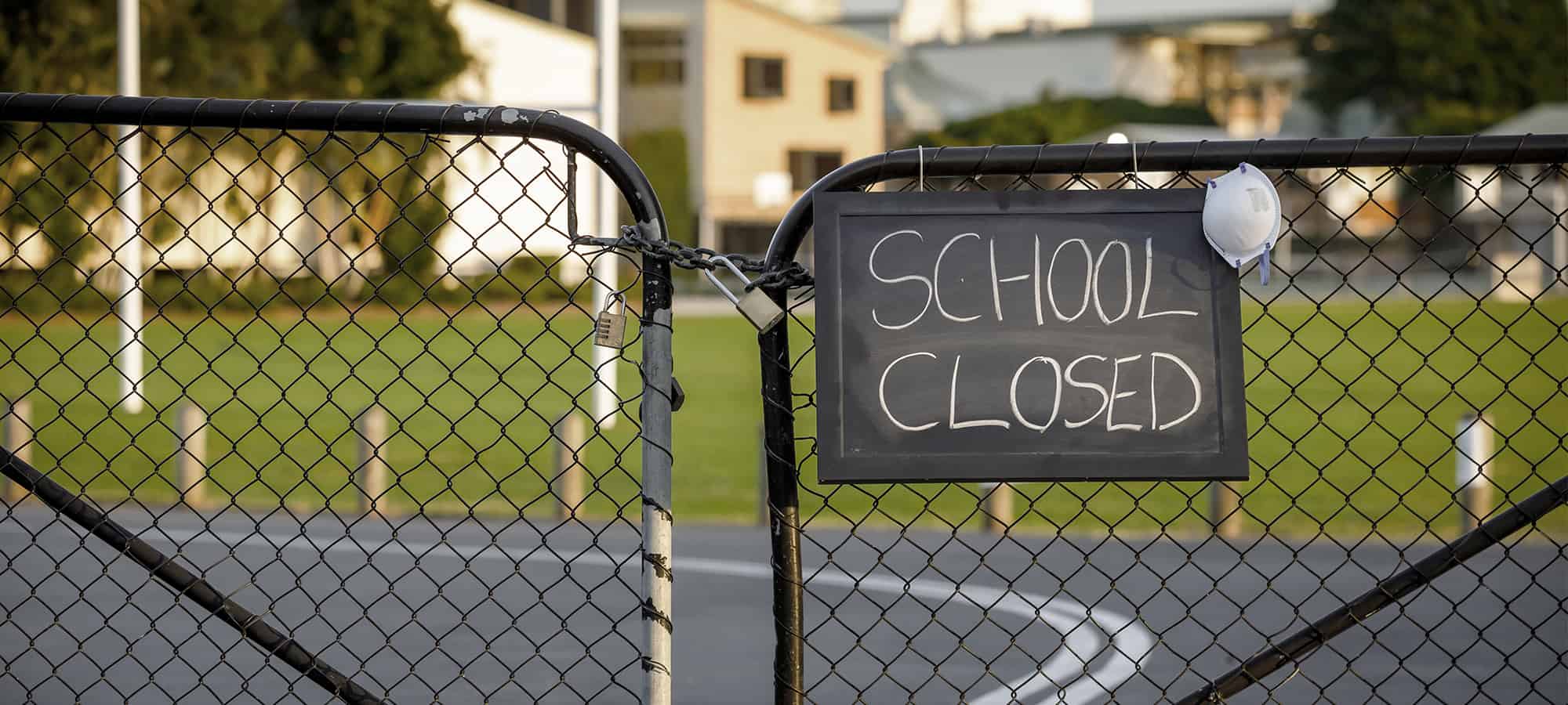 school gates closed with 'school closed sign' and mask due to crazy year of 2020 and coronavirus