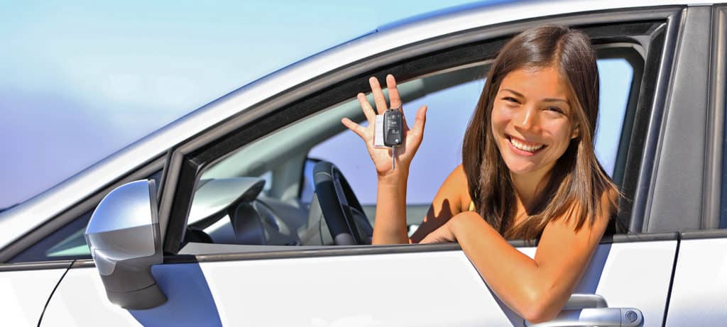 Teen holds keys happily after receiving license
