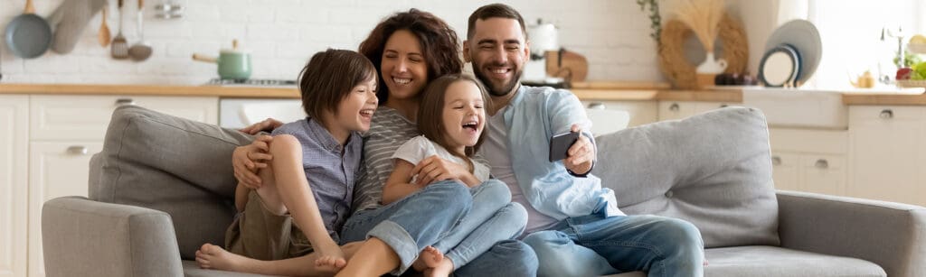 family sitting on couch together laughing